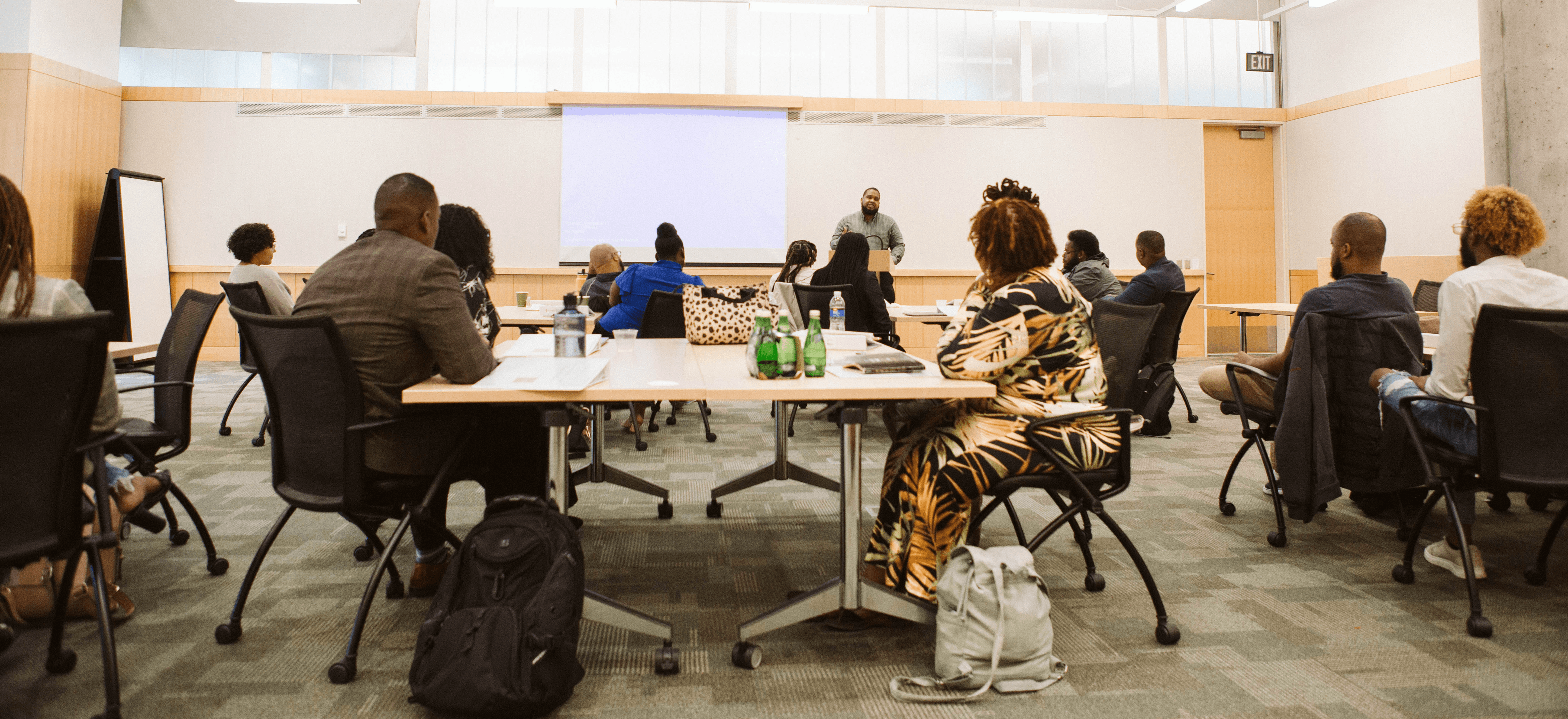 A group gathered in a classroom with a speaker teaching.
