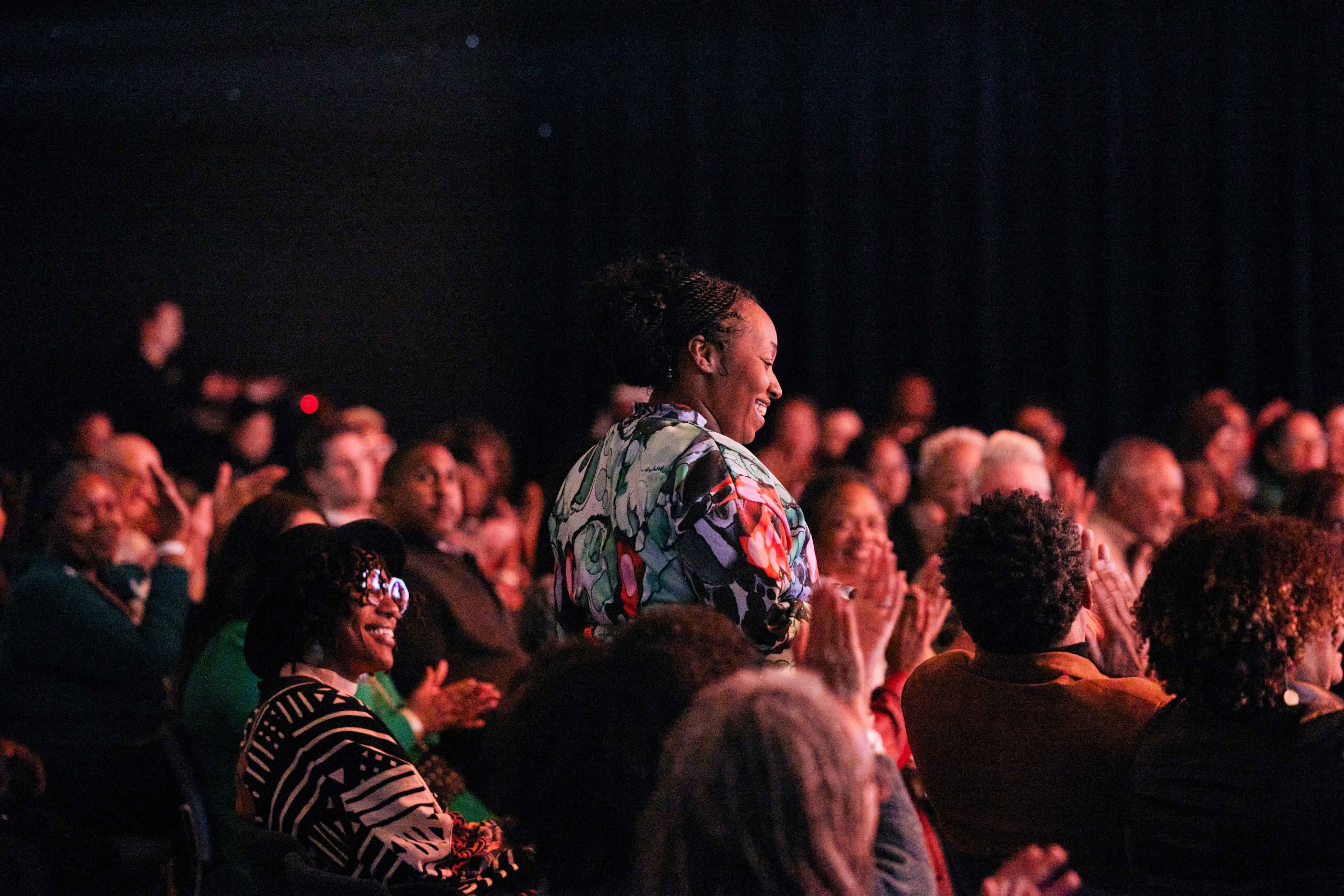 Woman being applauded at an event.